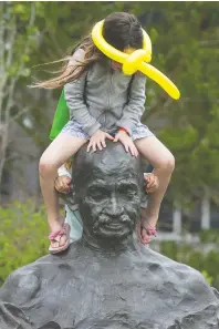  ??  ?? June 21
Children play on a statue of Mahatma Gandhi at Regina City Hall during National Indigenous Peoples Day.