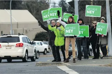  ?? — THE CANADIAN PRESS ?? Supporters wave signs with Green party candidate Michele Ney, centre, the Nanaimo byelection earlier this week. The party finished a distant third.