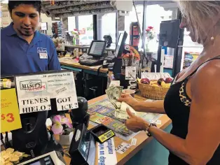  ?? ROBERT NOTT/THE NEW MEXICAN ?? Debbie Lynch of Santa Fe buys a Powerball ticket Thursday at the Allsup’s at Paseo de Peralta and North Guadalupe Street. While customers may be gambling just a few dollars at a time with each lottery ticket they buy, New Mexico has a lot more riding...