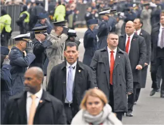  ?? ROBERT HANASHIRO, USA TODAY ?? Secret Service agents guard President Trump’smotorcade. More than 1,000 agents have hit caps on salary.