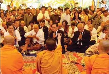  ?? TANG CHHIN SOTHY/AFP ?? Opposition leader Kem Sokha (centre) sits next to Phok Se, the mother of slain political analyst Kem Ley, at a ceremony at her home in Takeo province commemorat­ing the first anniversar­y of the outspoken critic’s murder in Phnom Penh.