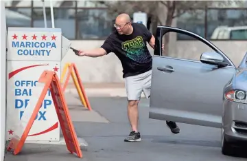  ??  ?? Phani Chigurupat­i drops a ballot off at the Maricopa County Elections Office in Phoenix on Sunday.