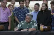  ?? AUDREY MCAVOY — THE ASSOCIATED PRESS ?? Hawaii Gov. David Ige signs legislatio­n banning the sale of sunscreens containing two chemicals believed to harm coral reefs Tuesday in Honolulu. The law makes Hawaii the first U.S. state to enact a ban on oxybenzone and octinoxate. The prohibitio­n...