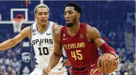  ?? RON SCHWANE / AP ?? Cleveland Cavaliers guard Donovan Mitchell (right) drives against San Antonio Spurs forward Jeremy Sochan on Feb. 13 in Cleveland.