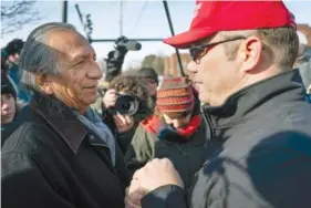  ?? AP PHOTO/BRYAN WOOLSTON ?? Guy Jones, left, and a supporter of President Donald Trump named Don join hands during a gathering of Native American supporters in front of the Catholic Diocese of Covington in Covington, Ky., on Tuesday. Jones organized Tuesday’s gathering.