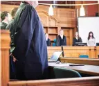  ?? (Annette Riedl/dpa via AP) ?? Trial participan­ts stand in room 500 at the Moabit Criminal Court Thursday at the opening of the trial against the two men accused of killing their sister in Berlin, Germany.