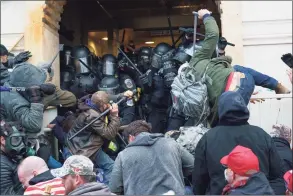  ?? JESSICA GRIFFIN / TNS ?? Supporters of President Donald Trump use bats, batons, and other items during a riot as they fight police defending an entrance to the U.S. Capitol in Washington, D.C., on Jan. 6.