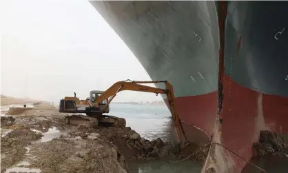  ?? Photograph: AP ?? A work crew using excavating equipment tries to dig out the Ever Given wedged across the Suez Canal