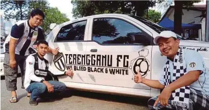  ??  ?? Zakaria (kanan), Mohd Hairie (tengah) dan Mohd Ramadhan bersama kereta yang dicorakkan logo TFC.