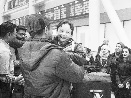  ?? Chris Young / THE CANADIAN PRESS ?? A six-year- old Syrian refugee is greeted by a family friend as he arrives with his parents and sisters at Toronto’s Pearson Airport on Wednesday.