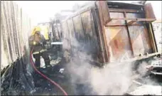  ?? KFSD photo ?? A fireman sprays water on a vehicle.