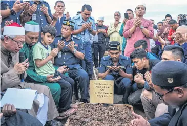  ??  ?? TRAGIC LOSS: Muslims offer prayers at Raudhatul Sakinah cemetery in Kuala Lumpur on Friday for a victim of Thursday’s school fire.