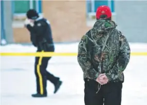  ??  ?? Aman holds a rosary Saturday as police investigat­e the scene of Friday’s shooting at La Loche Community School in Saskatchew­an. Jason Franson, The Canadian Press