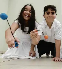  ??  ?? Giulia Palladino, 11 anos, e Matteo Piva, 10 anos, brincam com o bate-bola até no dia da catequese