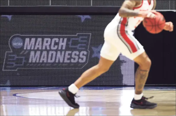  ?? Gregory Shamus / Getty Images ?? A video board with the March Madness logo is seen during the first half between the Ohio State Buckeyes and the Oral Roberts Golden Eagles in the first round game of the 2021 NCAA Men's Basketball Tournament at Mackey Arena on Friday in West Lafayette, Indiana.