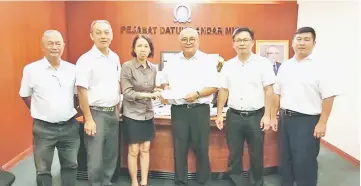  ??  ?? Mitraf 15 joint organising chairperso­n Jocelin Kuan presents an invitation letter to Yii.