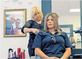  ?? KAYLA O’BRIEN/STAFF ?? Tania Mercader gets her hair straighten­ed by D’Magazine By Juan P Salon owner Angelita Velázquez, mother of Juan Pablo Rivera Velázquez, who was killed in the Pulse shooting. A photo of Rivera and his partner Luis Daniel Conde, also killed at Pulse,...