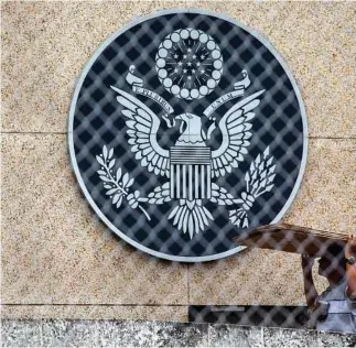  ?? Desmond Boylan / Associated Press ?? A worker carries cardboard at the U.S. Embassy compound in Havana. The U.S. has expelled several Cuban diplomats and recalled its own nonessenti­al diplomats after unexplaine­d health incidents.