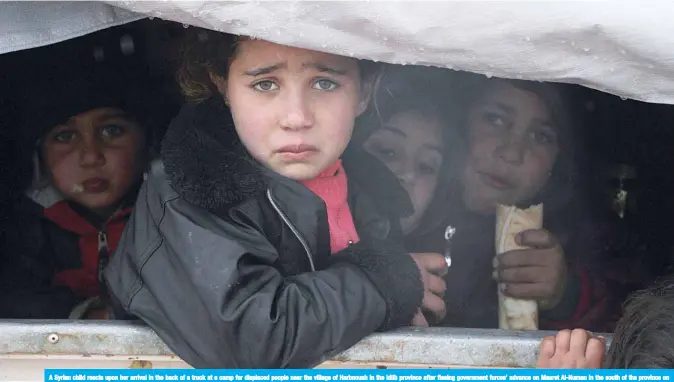  ?? —AFP ?? A Syrian child reacts upon her arrival in the back of a truck at a camp for displaced people near the village of Harbnoush in the Idlib province after fleeing government forces’ advance on Maaret Al-Numan in the south of the province on Saturday.