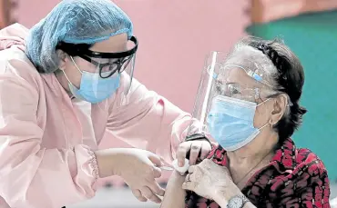  ?? —RICHARD A. REYES ?? BE NOT AFRAID An elderly woman in Pasay City shows there is nothing to fear as she gets her shot of the AstraZenec­a COVID-19 vaccine at Timoteo Paez Elementary School.