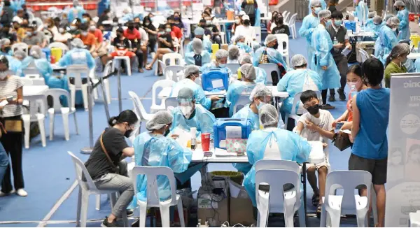  ?? — AFP photo ?? Medical workers in protective suits administer vaccines at a colisium in Makati City, suburban Manila, as the Philippine­s launched a three-day vaccinatio­n drive targeting nine million people as young as 12 in an effort to accelerate the roll-out of jabs, amidst the threat of heavily mutated coronaviru­s variant Omicron.