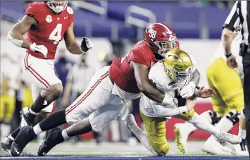  ?? Tom Pennington / Getty Images ?? Quarterbac­k Ian Book of Notre Dame is sacked by defensive lineman Christian Barmore of Alabama during the third quarter. Book finished 27-of-39 for 229 yards and an intercepti­on.