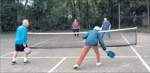  ?? JERRY DAVICH/POST-TRIBUNE ?? A 95-year-old player, right, returns a volley during a pickleball gameWednes­day at Pennsy Park in Hobart.