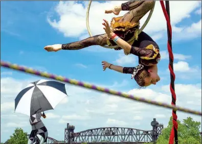  ?? Arkansas Democrat-Gazette/BENJAMIN KRAIN ?? Erica Gurley hangs from a hoop while performing aerial stunts Saturday with members of ReCreation Studios and Circus Arts during Riverfest in Little Rock. More photos are available online at arkansason­line.com/galleries.