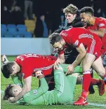  ??  ?? Dons players celebrate victory with hero keeper Freddie Woodman.