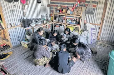  ?? REUTERS ?? Mah Tial’s family eats a meal inside a house at Farkawn village, in the northeaste­rn state of Mizoram, India.