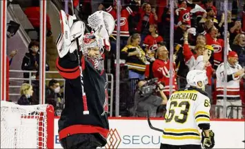  ?? Jared C. Tilton / Getty Images ?? Antti Raanta, left, of the Hurricanes celebrates a 3-2 victory as Brad Marchand of the Bruins skates away at the end of Game 7 on Saturday. Raanta had 27 saves in the win.