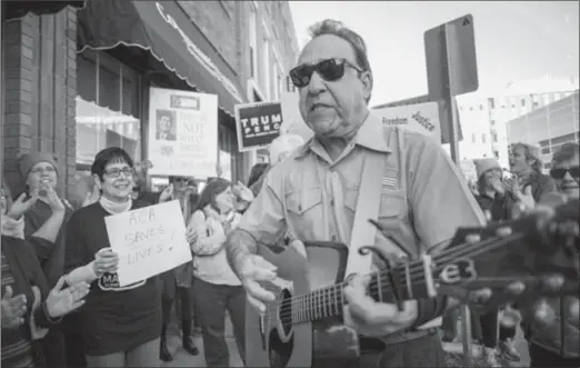  ?? ANGELA MAJOR, THE ASSOCIATED PRESS ?? John Spasaro, with Milwaukee’s Sing A Song Telegram, performs a version of “Please, Mr. Postman” with altered lyrics to House Speaker Paul Ryan outside of Ryan’s office in Janesville, Wis.