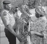  ?? AFP ?? A police officer stops the mothers of two kidnapped girls as they march to demand the rescue of their daughters.