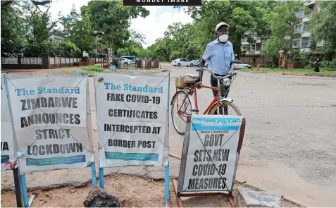  ?? | EPA-EFE ?? A MAN walks past newspaper headlines on the lockdown in Harare, Zimbabwe, yesterday. Zimbabwe recorded over 1 300 Covid-19 cases during the festive period, prompting the country’s health minister, Constantin­e Chiwenga, to impose a strict lockdown with effect from tomorrow.