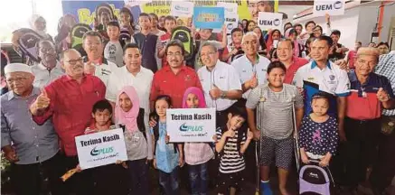  ?? [FOTO SAIFULLIZA­N TAMADI/BH] ?? Johari bersama Izzaddin dan Azman serta sebahagian kanak-kanak pada Program Kembali Ke Sekolah UEM-PLUS di Pusat Komuniti Taman Maluri, semalam.