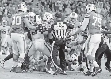  ?? CHARLES TRAINOR JR. ctrainor@miamiheral­d.com ?? Dolphins and Bills players get into a fight late in the fourth quarter at Hard Rock Stadium on Dec. 31, 2017, one of many dust-ups between the two AFC East rivals over the years.