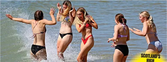  ?? ?? Thank God it’s Fry-day! A group of friends take a dip in the surf at Bournemout­h beach yesterday