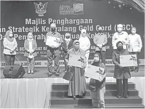  ??  ?? UNTUK ALBUM: Fatimah (empat kanan, belakang) diapit Francis Harden (tiga kanan, belakang) dan Rosey (empat kiri, belakang) merakam kenangan bersama lima penerima KGC di Kuching, semalam.