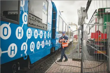  ??  ?? The Coradia ilint, a hydrogen-powered regional train, is shown at a fueling station in Salzgitter, Germany. Using hydrogen on an airplane, which would need to f ly all over the world, would be trickier; Airbus has experiment­ed with using hydrogen to...