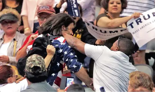  ?? PICTURE: MIKE CHRISTY/ARIZONA DAILY STAR
VIA
AP ?? FIGHT NIGHT: Trump protester Bryan Sanders, centre left, is punched by a Trump supporter as he is escorted out of Republican presidenti­al candidate Donald Trump's rally at the Tucson Arena in downtown Tucson, Arizona, on Saturday.