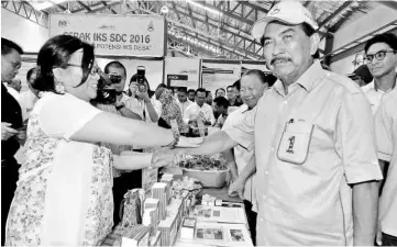  ??  ?? Chief Minister Datuk Seri Musa Aman trying out the locally made medicated oil. - Bernama photo