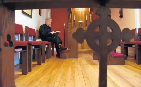  ?? KIM HAIRSTON/BALTIMORE SUN ?? The Rev. Tom Slawson, rector of St. Peter’s Episcopal Church, prepares to lead morning prayers. He came to St. Peter’s two months after a double homicide at the church.