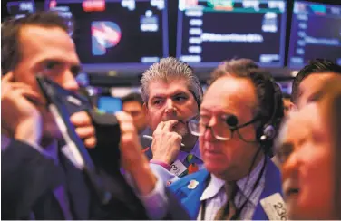  ?? Michael Nagle / Bloomberg ?? The prospect of a trade war weighed on the floor of the New York Stock Exchange, where U.S. stocks fell.