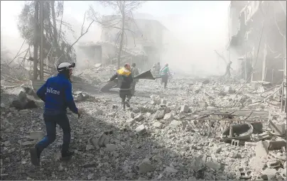  ?? AP PHOTO ?? This photo released on Tuesday provided by the Syrian Civil Defense group known as the White Helmets shows members of the Syrian Civil Defense run to help survivors from a street that attacked by airstrikes and shelling of the Syrian government forces,...