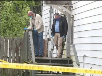  ?? The Sentinel-Record/Richard Rasmussen ?? CRIME SCENE: Garland County Coroner Stuart Smedley, left, and Hot Springs Police Sgt. Mike Hall work the scene of a homicide Tuesday morning at 307 Oakcliff St. A local man, Terry Eugene Hughes, 55, has been charged with first-degree murder for the death of Joshua David Buck, 43, who lived at the Oakcliff Street apartment.
