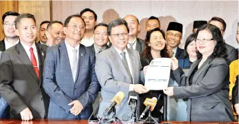  ??  ?? Anita, who was PBS Women's chief, hands over her Warisan membership applicatio­n form to Shafie, watched by other Warisan leaders yesterday.
