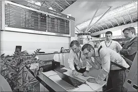  ?? [SERGEI CHUZAVKOV/THE ASSOCIATED PRESS] ?? Airport employees use a laptop computer Tuesday at Boryspil airport in Kiev, Ukraine, during a mass disruption caused by ransomware. Ukraine was hit especially hard.