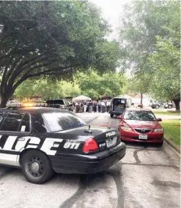  ??  ?? People gather outside a house in Round Rock, Texas, where Travis County Sheriff’s deputy Sgt. Craig Hutchinson was shot and killed at his home before dawn on Monday.