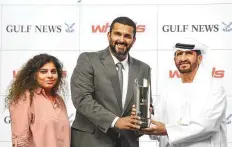  ?? Ahmad Ramzan/ Gulf News ?? Sony Thomas (centre), Editor, Wheels, and Priya Nair (left), Sales Manager, hand over the trophy to Ali Rashid Al Rayhi who trained Quartier Francais to win the Wheel handicap, the concluding race of the Gulf News-sponsored meeting.