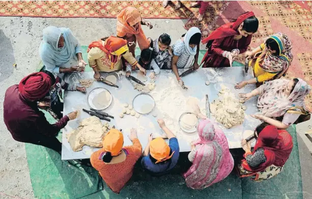  ?? BURHAAN KINU / GETTY ?? Preparació del ‘langar’, el dinar tradiciona­l dels sikhs que es comparteix amb tothom. La imatge correspon a la localitat índia de Noida el 2105